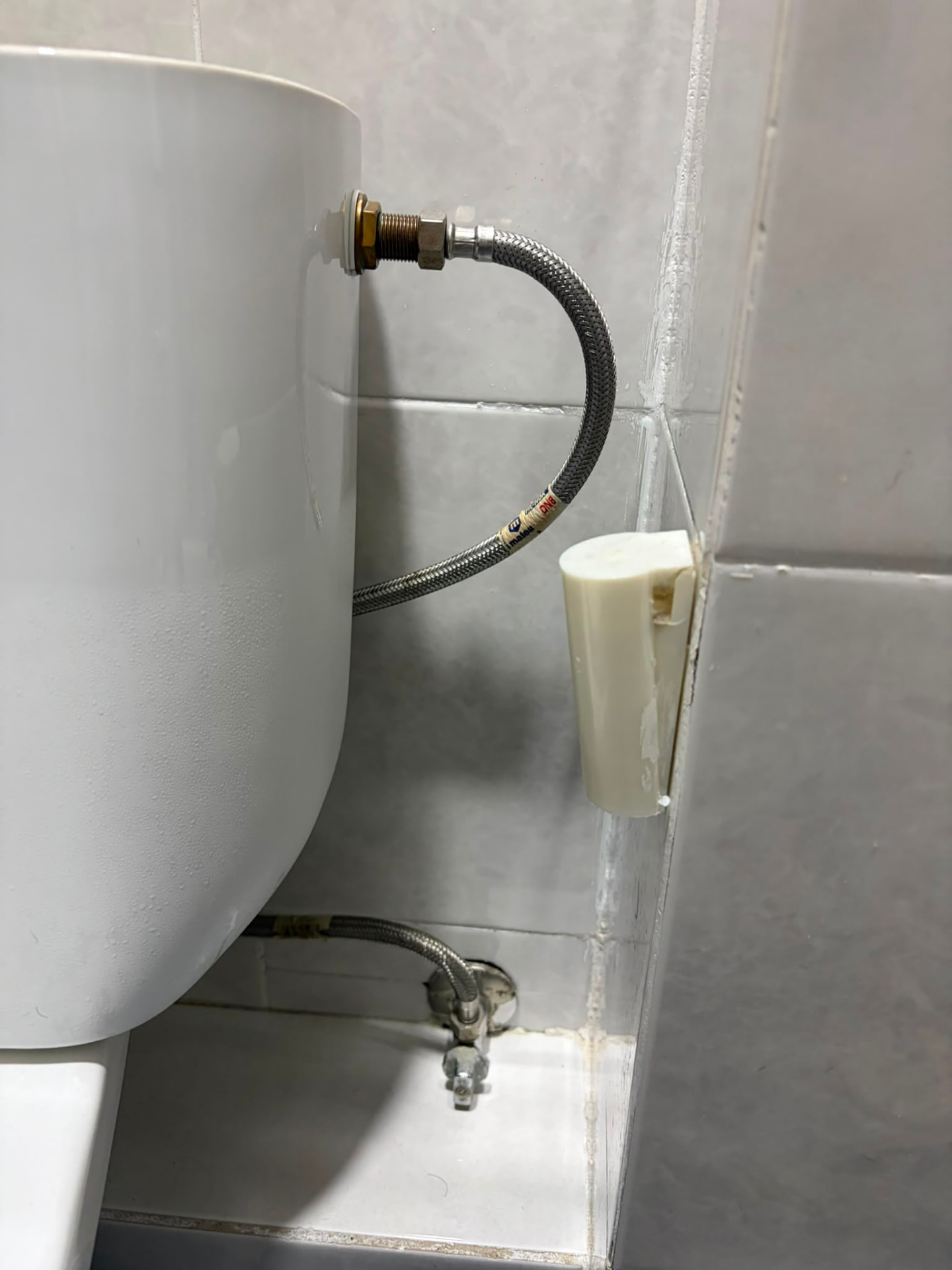 Instalación terminada de latiguillos y llave de paso del inodoro